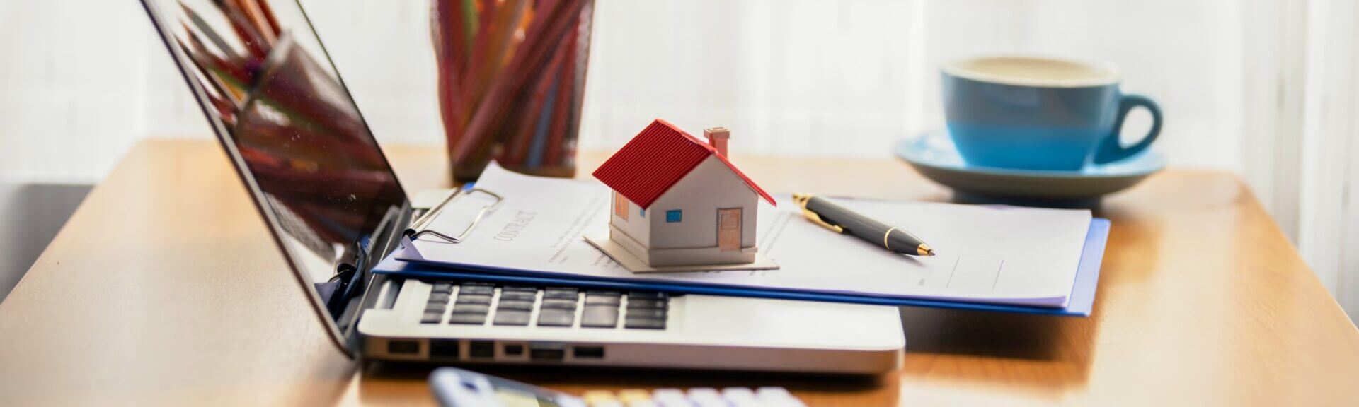 Notebook with little house on top of laptop